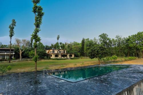 a pool of water with a house in the background at Hideaway By Aahma in Rāmnagar