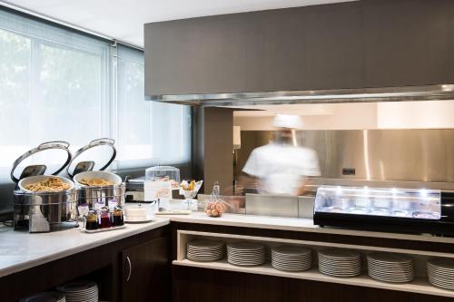 a kitchen with a person in the kitchen at Catalonia Atenas in Barcelona