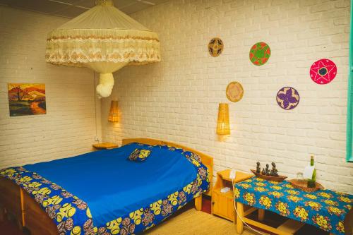 a bedroom with a blue bed and a table at Isange Paradise Resort in Ruhengeri