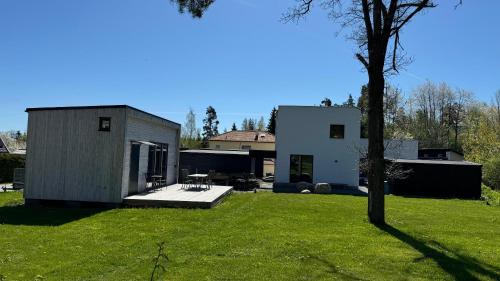 a large yard with a house and a tree at Gästhus i Nacka in Boo
