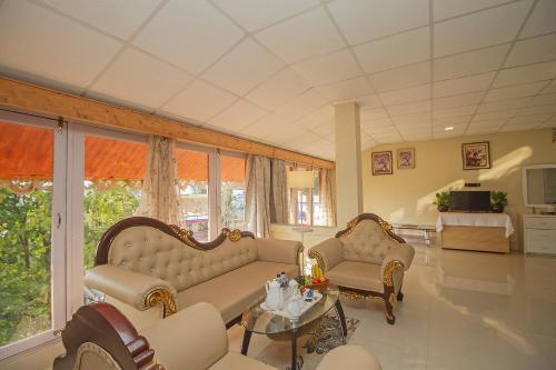 a living room with two couches and a table at Mount Queens Hill Resort & Spa in Mirik