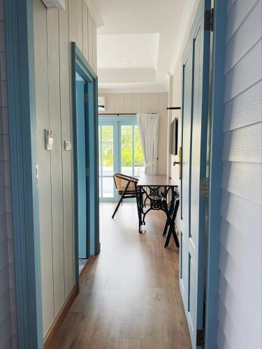 a hallway with blue doors and a table in a room at Wiengket Heritage 1964 in Bangkok