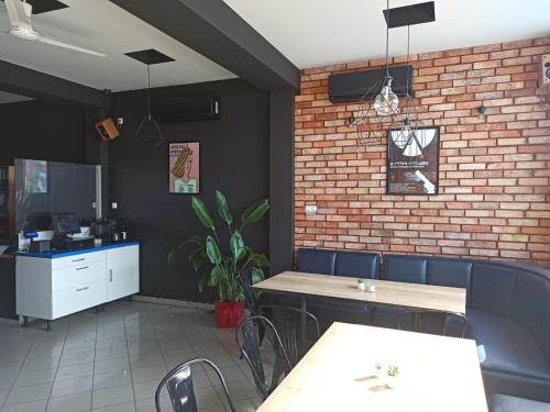 un restaurant avec des tables et des chaises et un mur en briques dans l'établissement Pokoje nad pizzerią, à Poznań