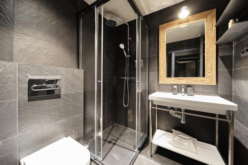 Luxury Ski Chalet Andorra في سولديو: حمام مع دش ومغسلة ومرآة