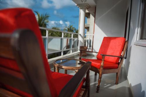 a balcony with two chairs and a table at Maison Stella Lome in Lomé