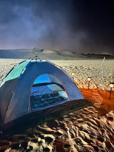 a blue tent sitting on the sand in the desert at Dubai Tourism and Travel Services in Hunaywah