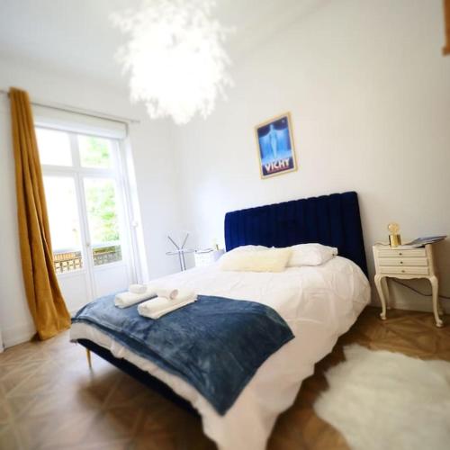 une chambre avec un grand lit et une fenêtre dans l'établissement Les Ambassadeurs quartier Opéra, à Vichy