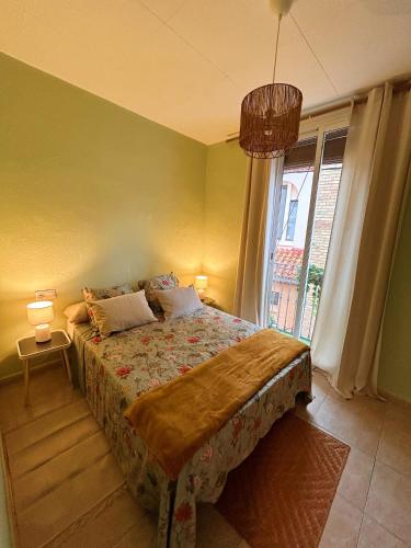 a bedroom with a bed and a large window at Central Market Apartment in Calella