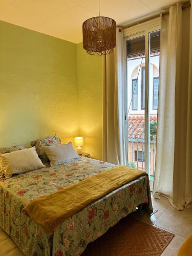 a bedroom with a bed and a large window at Central Market Apartment in Calella