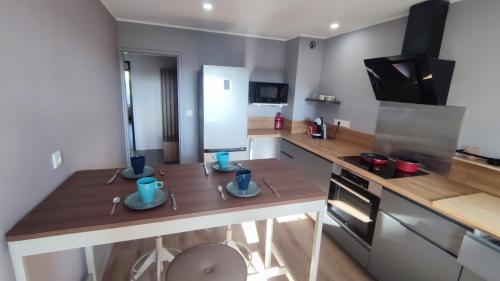 une cuisine avec deux tasses bleues sur un comptoir en bois dans l'établissement T4 Rénové sur Balcons, Proche Mourillon - TOULON, à Toulon