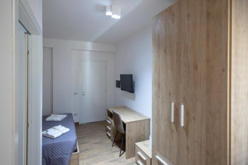 a room with two beds and a wooden cabinet at Elysium Affittacamere in Mazara del Vallo