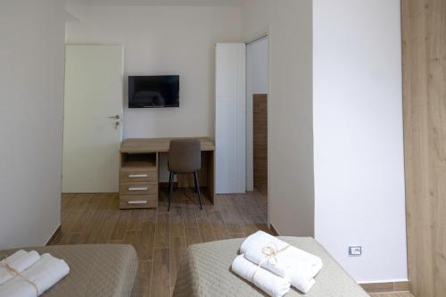 a hotel room with two beds and a desk at Elysium Affittacamere in Mazara del Vallo