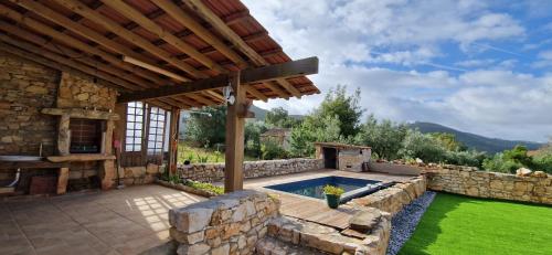 a backyard with a swimming pool and a stone wall at Casa do casal POIOS in Pombal