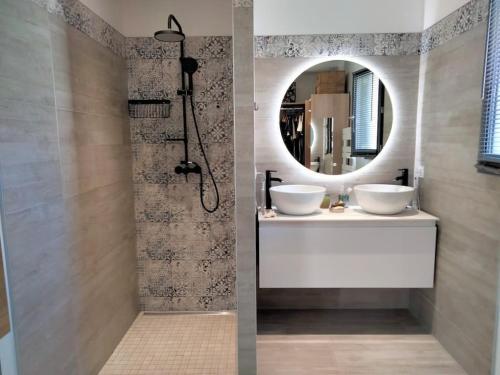 une salle de bain avec deux lavabos et un miroir dans l'établissement Maison climatisée avec piscine chauffée, à Cazilhac