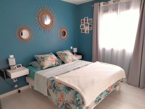 - une chambre bleue avec un lit et un miroir dans l'établissement Maison climatisée avec piscine chauffée, à Cazilhac