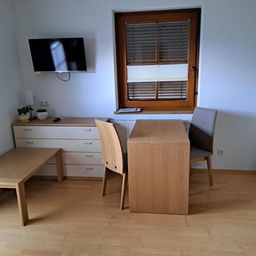 a room with a table and chairs and a desk at Ferienwohnung Schlemmer Romed Dolomitenblick in Nußdorf