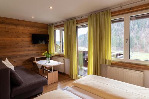 a bedroom with a bed and a couch and windows at Gästehaus Kasbichler in St. Wolfgang