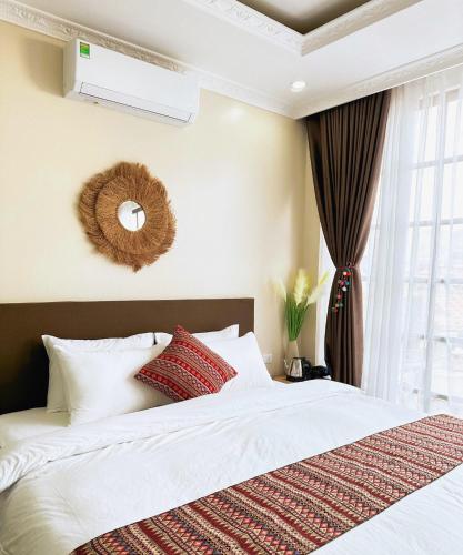 a bedroom with a bed with white sheets and red pillows at Love House Homestay SAPA in Sa Pa