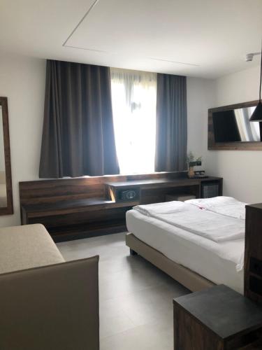 a hotel room with two beds and a television at Villa Regina in Riva del Garda