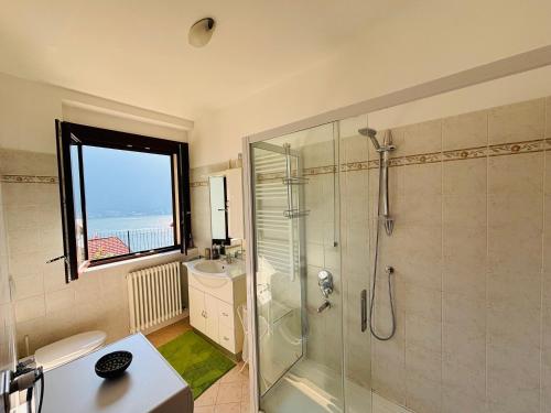 a bathroom with a glass shower and a sink at Incanto Nesso Parking and Lake View in Nesso