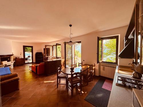 a living room with a table and a dining room at Incanto Nesso Parking and Lake View in Nesso