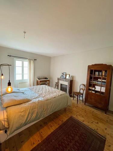 une chambre avec un lit, une table et une fenêtre dans l'établissement Maison de charme proche du lac, à Royère-de-Vassivière