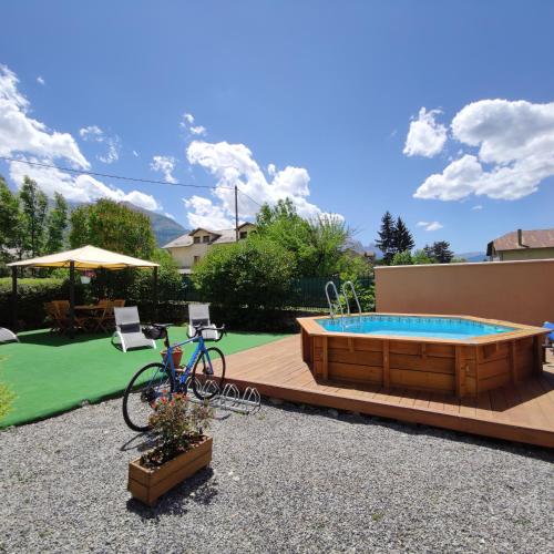 un vélo est garé à côté d'une piscine dans l'établissement Chambre d'Hotes La Mexicaine, à Jausiers