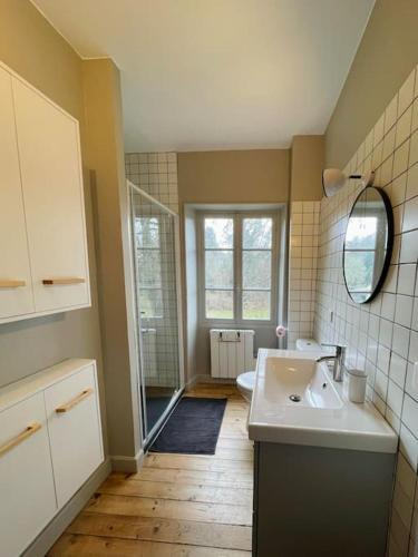 une salle de bain avec un lavabo et un miroir dans l'établissement Maison de charme proche du lac, à Royère-de-Vassivière