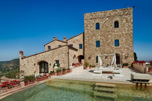 duży budynek z basenem przed nim w obiekcie Castello di Velona Resort, Thermal SPA & Winery w mieście Montalcino