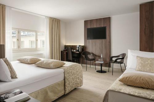 プラハにあるMichelangelo Grand Hotelのベッドとデスクが備わるホテルルームです。