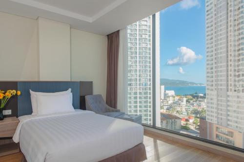 a bedroom with a bed and a large window at ARECA HOTEL NHA TRANG in Nha Trang