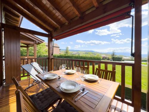 une table en bois sur une terrasse avec une grande fenêtre dans l'établissement El Balcó de Nahuja, à Nahuja