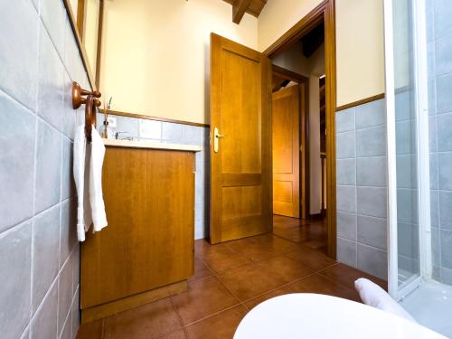 La salle de bains est pourvue d'un lavabo et d'une porte en bois. dans l'établissement El Balcó de Nahuja, à Nahuja