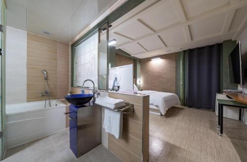 a bathroom with a sink and a bed in a room at Hotel Trip in Incheon