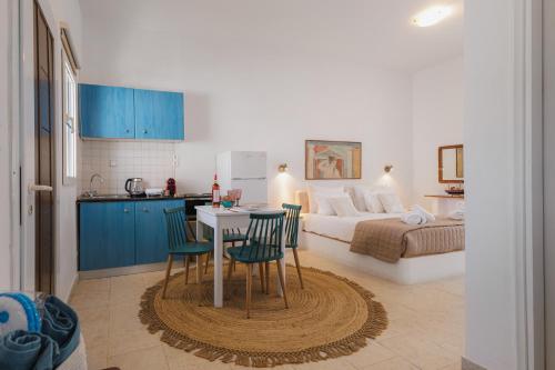 a kitchen and a bedroom with a bed and a table and chairs at Studios Eliza in Livadion