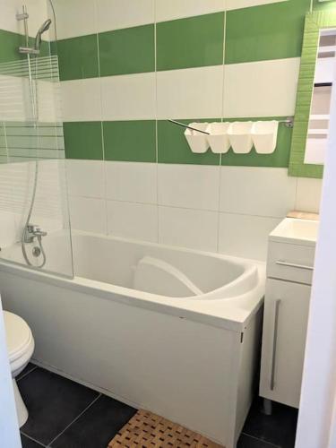 une salle de bain avec une baignoire blanche et des toilettes dans l'établissement Studio 25m2, 5 pers, 30m des pistes, balcon sud, à Villard-de-Lans