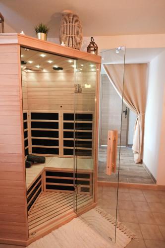 une armoire en verre avec une porte en verre dans une pièce dans l'établissement Le Refuge: Maison détente et spa, à Brix