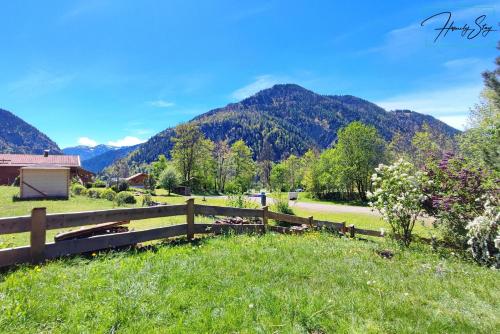 a fence in a field with mountains in the background at Homely Stay Velosoph Quartier in Bayrischzell