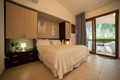 a bedroom with a large bed and a balcony at Villaggio San Matteo Resort in Mattinata
