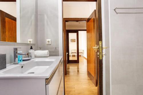 Biała kuchnia ze zlewem i korytarzem w obiekcie Home Music Apartments w Porto