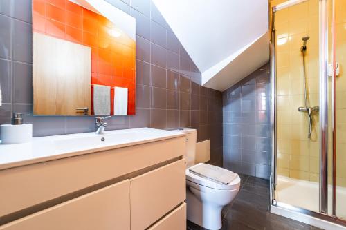een badkamer met een toilet, een wastafel en een douche bij Casas da Alegria in Coimbra