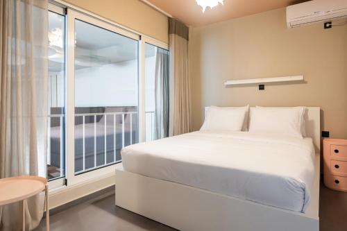 a bedroom with a bed and a large window at The Gate by Zoia Living in Athens