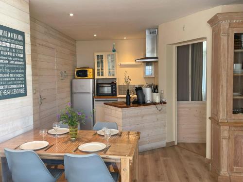 une cuisine avec une table et des chaises en bois ainsi qu'une cuisine avec un comptoir dans l'établissement clos de la poudriere, à Saint-Martin-de-Ré