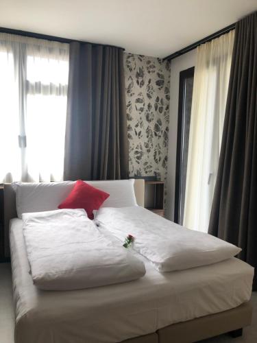 a bedroom with a white bed with a red pillow at Villa Regina in Riva del Garda