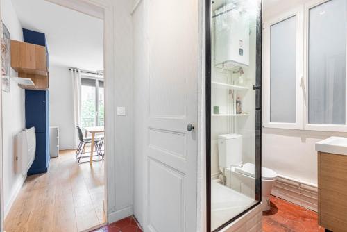 La salle de bains est pourvue de toilettes et d'une porte en verre. dans l'établissement GuestReady - Cosy Nest near Place de la Bastille, à Paris