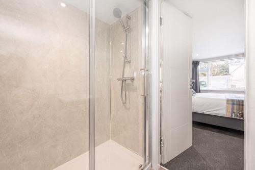 um chuveiro com uma porta de vidro num quarto em Ramsey Guesthouse IOM em Ramsey