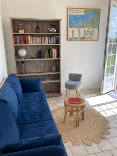 een woonkamer met een blauwe bank en een stoel bij Clos Phitarra, charmant gîte pour 2 personnes à 7 mns d'Etretat in Les Loges