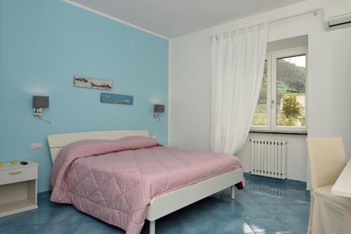 a bedroom with a pink bed and a window at Aquarius Maiori B&B in Maiori