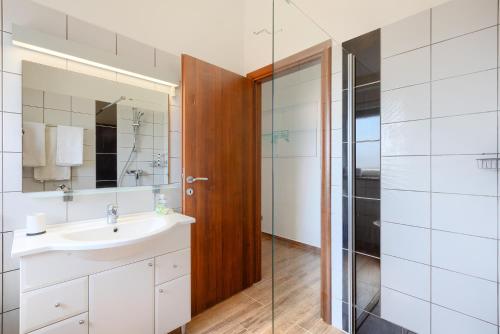 uma casa de banho com um lavatório e uma cabina de duche em vidro. em Villa Lara I em Ližnjan