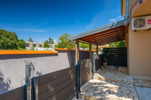 a house with a wooden fence and a gate at Villa Lara 1 in Ližnjan